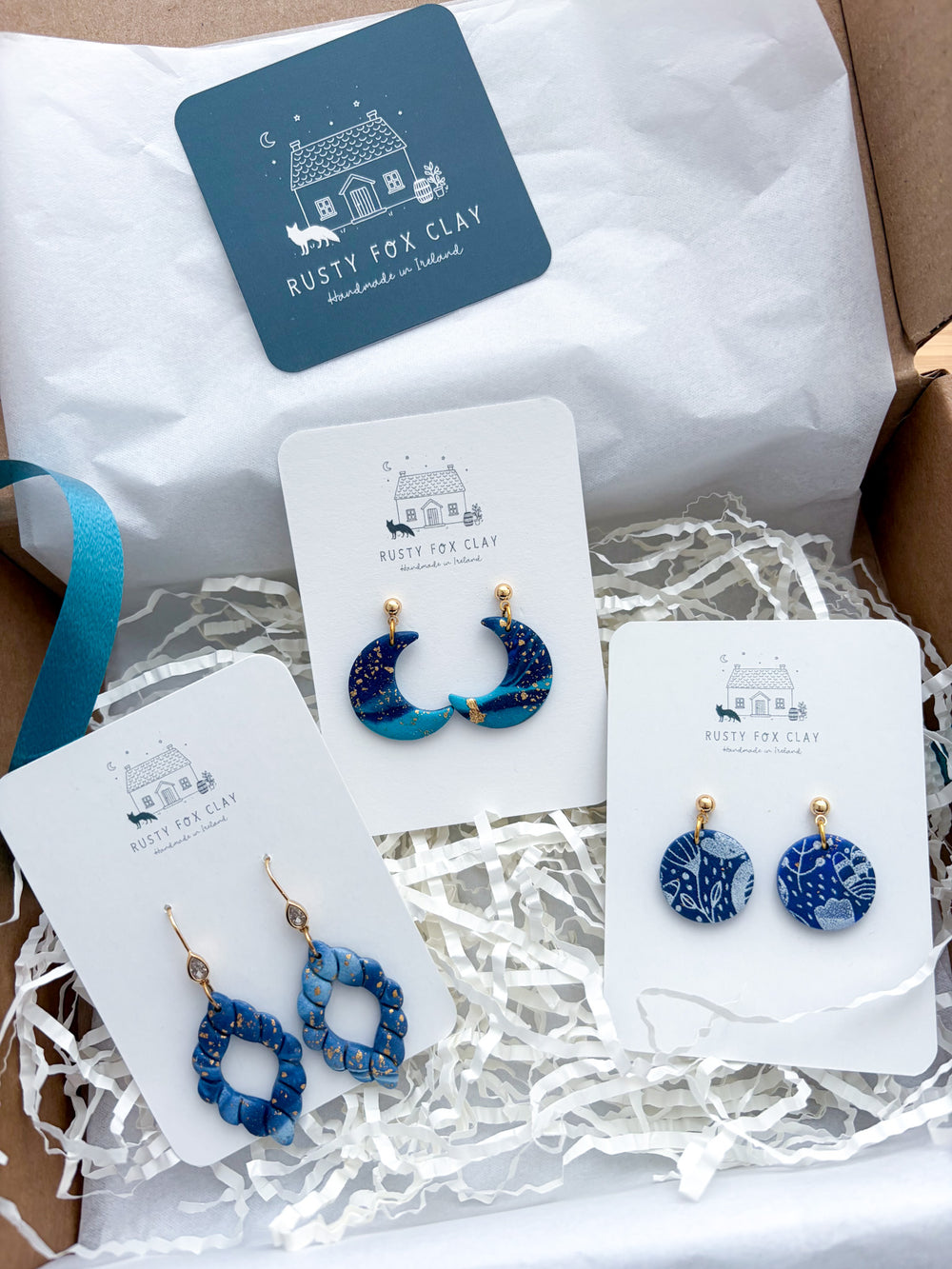 A display of 3 pairs of Handmade earrings on branded card inside a packaging box. Each piece, handmade in Mayo, Ireland.